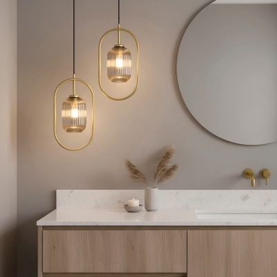 Armário de casa de banho em madeira clara com tampo branco, espelho redondo e luminárias pendentes douradas