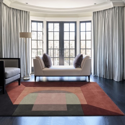 Tapete geométrico em tons terra numa sala moderna com sofá branco e cortinas cinza