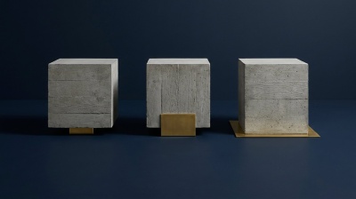 Três cubos de betão iguais e ao mesmo nível, cada um assente numa chapa de latão de área diferente