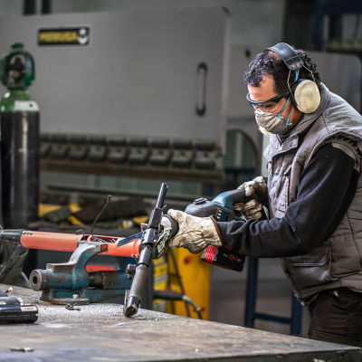 Homem a usar pistola de ar comprimido numa oficina