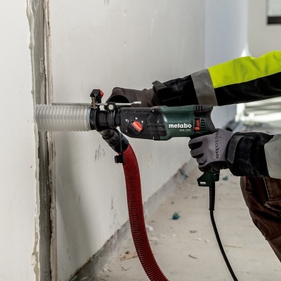 Pessoa a usar ferramenta elétrica Metabo para perfuração de parede