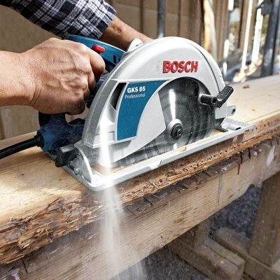 Serra circular elétrica Bosch a cortar madeira com pó a sair