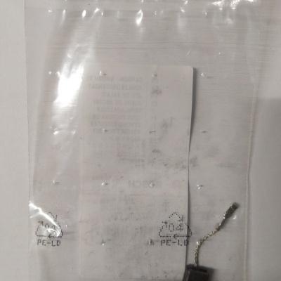 Saco plástico transparente com duas escovas de carvão pretas com fios e terminais metálicos