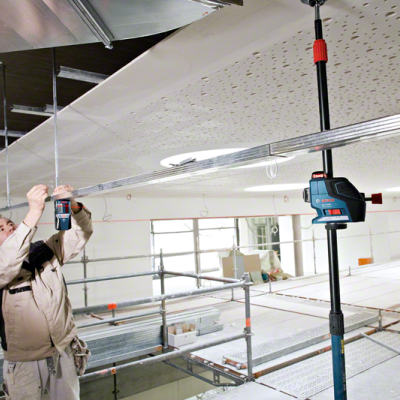 Ator a usar ferramenta elétrica Bosch para instalar estrutura no teto num espaço industrial