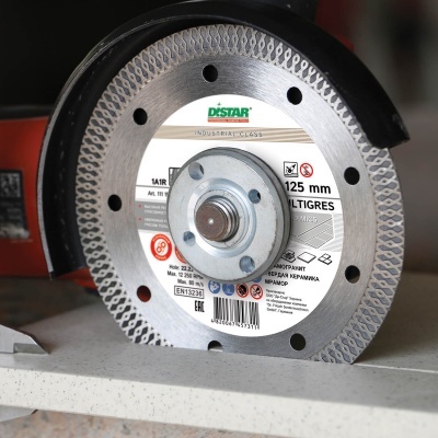 Disco de corte cortando superfície, com etiqueta DISSTAR e 125 mm visíveis