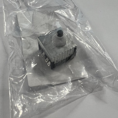 Interruptor ou temporizador preto e cinzento embalado numa bolsa plástica