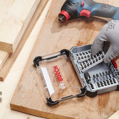 Conjunto de pontas para aparafusadora Bosch num estojo transparente com ferramenta elétrica e tábuas de madeira