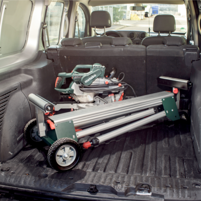 Máquina de corte Metabo cinza e verde com rodas na bagageira de veículo preto