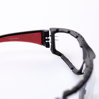 Óculos de proteção com armação preta e vermelha e lentes transparentes