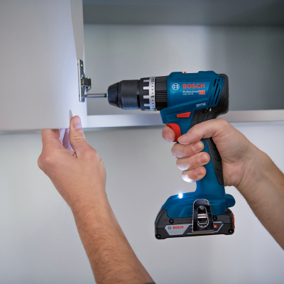 Parafusadeira Bosch a aparafusar dobradiça de armário branco dentro de casa