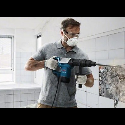 Homem a demolir parede com martelo perfurador azul e preto