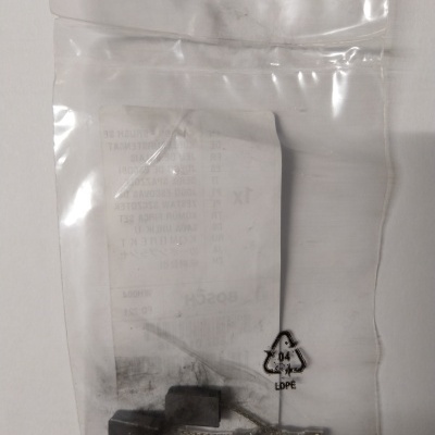 Bolsa plástica transparente com duas escovas de carvão pequenas e peça metálica