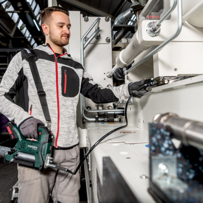 Homem com ferramenta elétrica Metabo num ambiente industrial