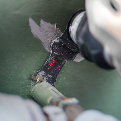 Ferramenta preta com etiqueta RUBI TOOLS raspa superfície verde