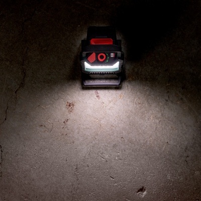 Lanterna preta e vermelha sobre chão cinzento