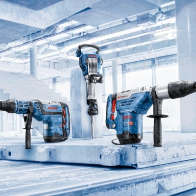 Três martelos perfuradores azuis e pretos em local industrial