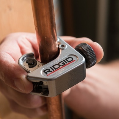 Aparelho cinzento RIDGID a cortar tubo de cobre em ambiente interior
