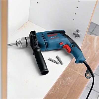 Berbequim elétrico Bosch azul e preto com punho lateral preto sobre superfície branca
