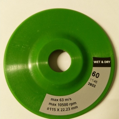 Disco abrasivo verde com etiquetas e texto técnico sobre fundo branco