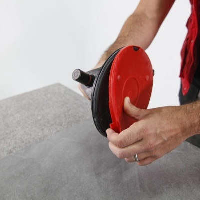 Máquina de polir vermelha e preta nas mãos de uma pessoa