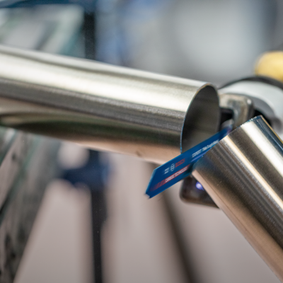 Dois tubos metálicos cilíndricos prateados, com etiqueta azul, em ambiente industrial