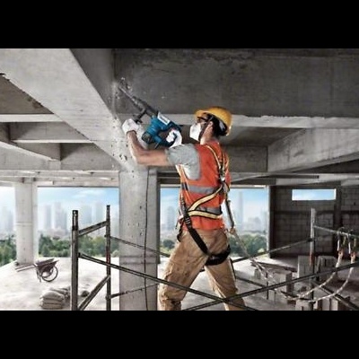 Trabalhador de construção perfurando parede de betão