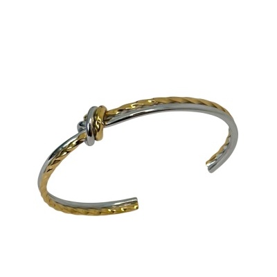Pulseira aberta em metal dourado e prateado com nó decorativo