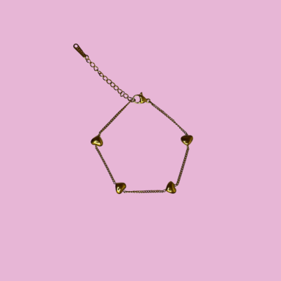 Pulseira dourada com corações em fundo rosa