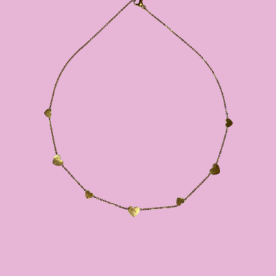 Colar dourado com corações em fundo rosa