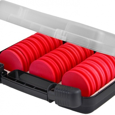 Estojo preto aberto com pastilhas vermelhas redondas