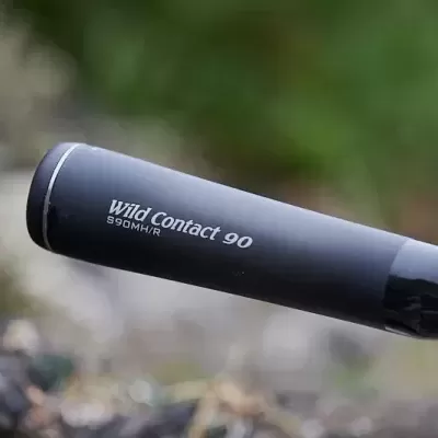 Detalhe de cana de pesca preta Wild Contact 90 com texto branco em ambiente natural
