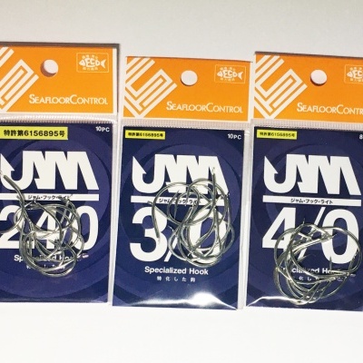 Três pacotes de anzóis de pesca UMA SEAFOOD CONTROL em fundo branco