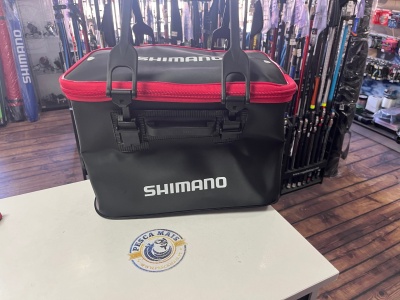 Saco de pesca preto e vermelho Shimano sobre mesa branca com autocolante PESCA MAIS