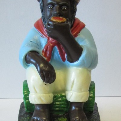 Figura decorativa de homem sentado com chapéu e roupas coloridas