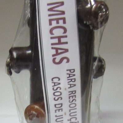 Cilindro preto com saliências castanhas embalado em plástico com etiqueta branca