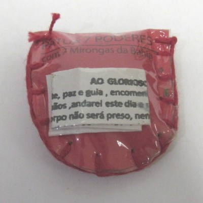 Saquinho vermelho com cordão dentro de embalagem plástica transparente e papel com texto em português.