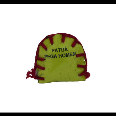 Amuleto de tecido amarelo com texto preto 'PATUÁ PEGA HOMEM' e detalhes vermelhos