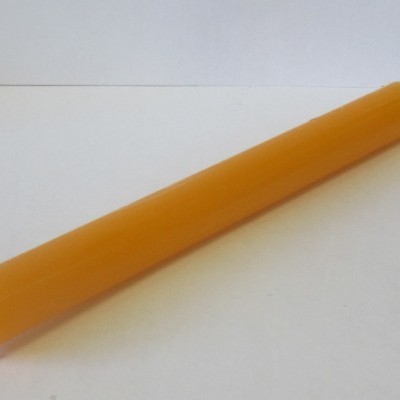 Vela cilíndrica amarelo-laranja sobre superfície branca