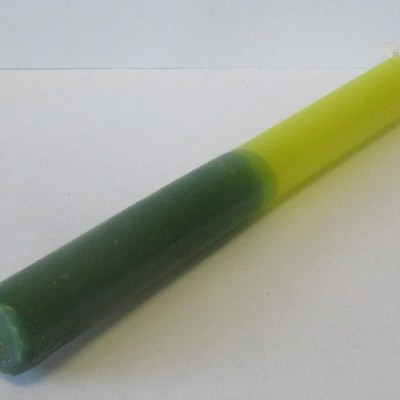 Vela cilíndrica verde e amarela sobre fundo branco