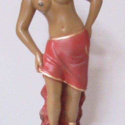 Estátua de mulher topless com saia vermelha e base preta com placa dourada