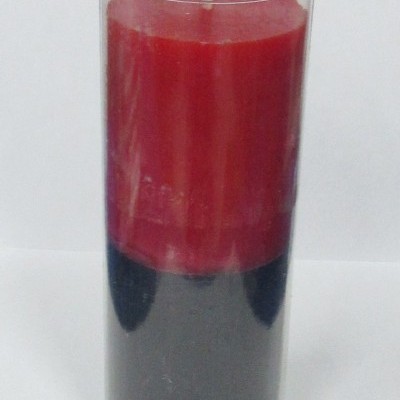 Vela vermelha e preta em copo de vidro transparente