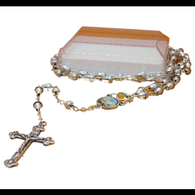 Terço católico prateado com crucifixo e medalha sobre base branca