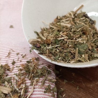 Mistura de ervas secas em prato branco e tecido riscado rosa e branco