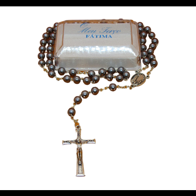 Rosário prateado com embalagem etiquetada Mon Sexe FATIMA sobre fundo preto