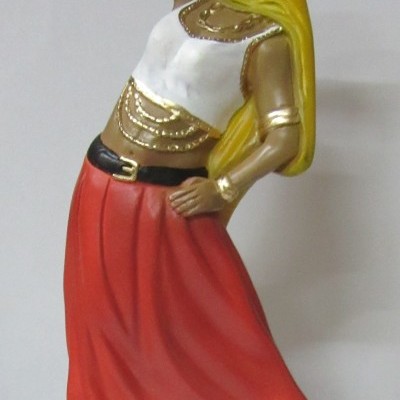 Estatueta de mulher com vestido vermelho, lenço amarelo e cartas na mão em base verde e preta.