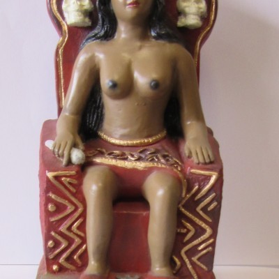 Estátua feminina sentada num trono vermelho com caveiras e detalhes dourados