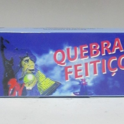 Caixa azul com texto 'QUEBRA FEITIÇO' e imagem colorida com figura humana segurando objeto luminoso
