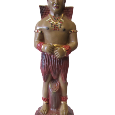 Estátua decorativa de homem com saia vermelha, asas e colar colorido em base preta com texto.