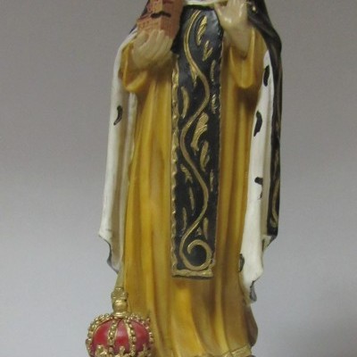 Estátua de Santa Edwiges com hábito amarelo e preto, segurando castelo, coroa na base e placa 'S.EDWIGES'.