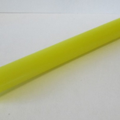 Vela longa amarela com pavio branco sobre superfície branca